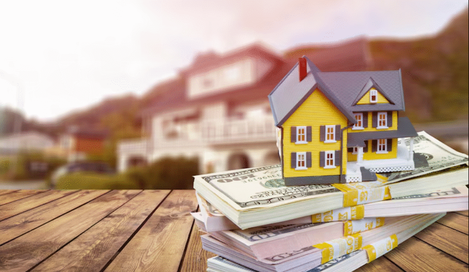 Mini home with stack currency money on wooden desk in the article: Small Lots Big Impacts
