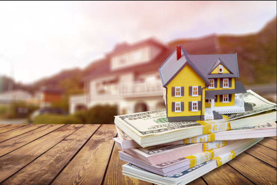 Mini home with stack currency money on wooden desk in the article: Small Lots Big Impacts