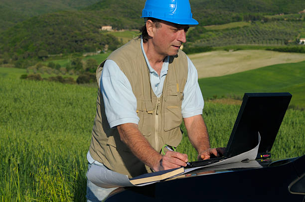 man typing on laptop for permit of land