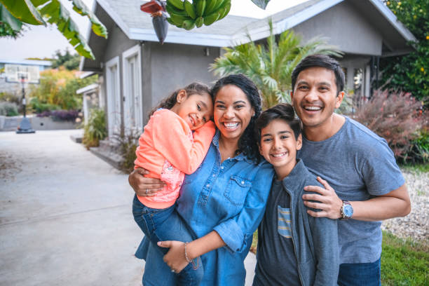 Portrait of happy family against house. Multi-ethnic parents and children are smiling on driveway. They are having fun together during weekend. SB 684