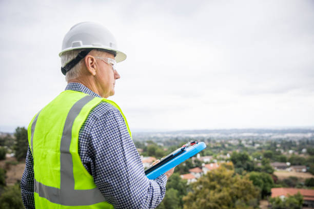A senior construction site manager visually inspects a building project