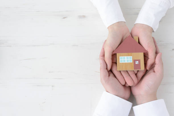Couple's hands with house object