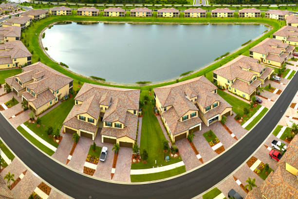 View from above of densely built residential houses near retention ponds in closed living clubs in south Florida. American dream homes as example of real estate development in US suburbs.