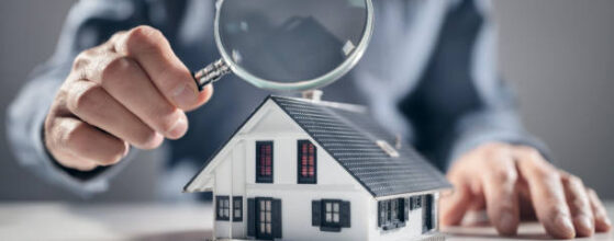 House with ith man holding magnifying glass concept for home inspection or searching for a new house