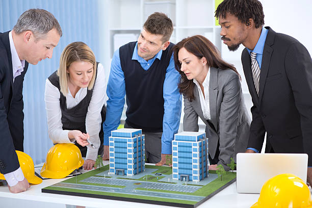"Group of architects discussing about their new project - office building model.See more BUSINESS PEOPLE in OFFICE, CALL CENTER REPRESENTATIVES and ARCHITECTS with their PROJECT from this session. Click on images below for lightbox."