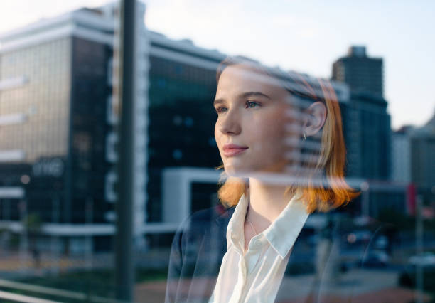 Business woman, window and thinking for urban development, inspiration for architecture and infrastructure. Reflection, innovation and insight with property, ideas and future of profession for growth