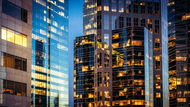 Q Conditions and Q Removal Office lights illuminating a collection of modern downtown office towers after sunset.