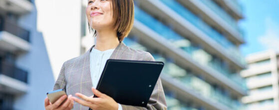Businesswoman standing in front of an apartment building on fine day - Cash Investment in Los Angeles