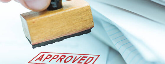 man stamping approved documents or project, shallow depth of field, focus on stamp