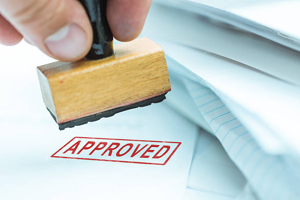 man stamping approved documents or project, shallow depth of field, focus on stamp