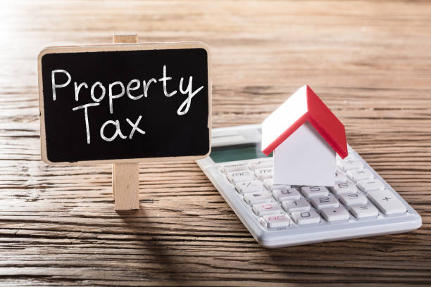Property Tax Written On Blackboard With House Model On Calculator