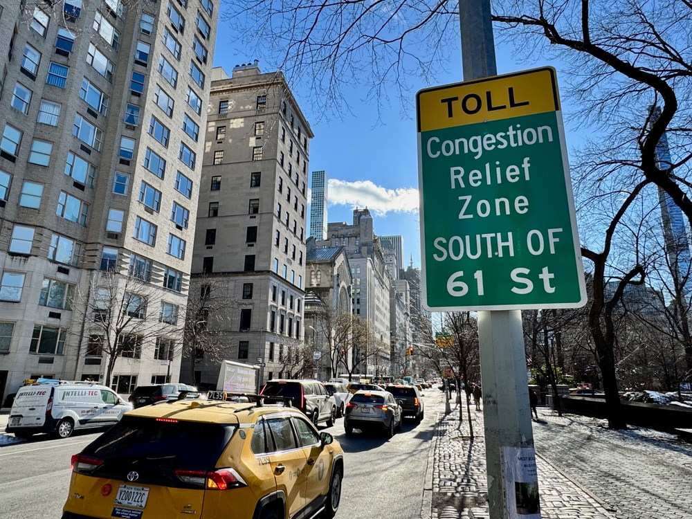 New York, NY USA - January 7, 2025 : Cars driving down Fifth Avenue next to a "Toll: Congestion relief zone south of 61 Street" sign on the Upper East Side of Manhattan, New York City