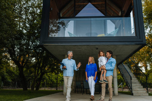 Family standing outside of their new home with their real estate agent