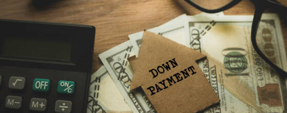 Selective focus of pen. glasses, calculator, money and cardboard home written with Down Payment on wooden background.