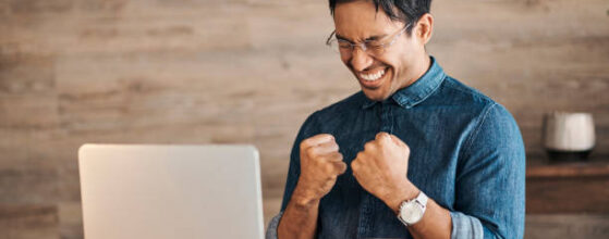 Success, winner and businessman on laptop with coffee celebrating winning, business deal or sales growth. Wow, entrepreneur or male from Canada in celebration of financial goals, mission or targets.